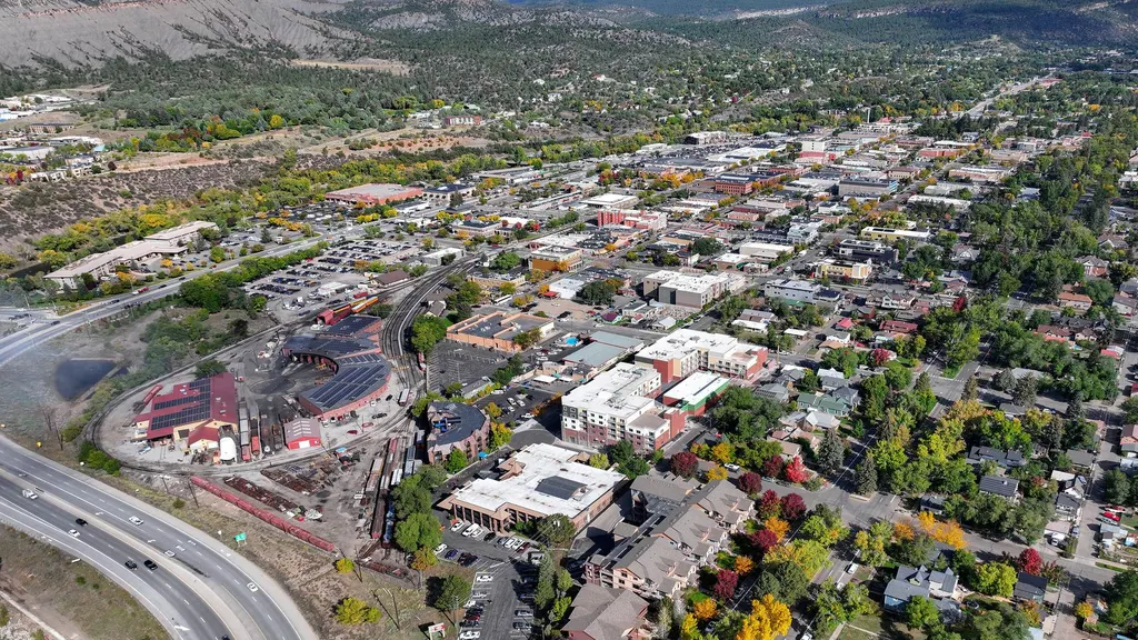 Aerial view of downtown Durango streets, rail yard and highway with mountains in the distance